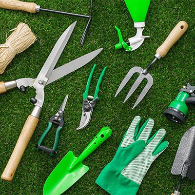 Image of gardening tools lying in the grass.